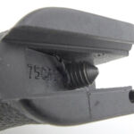 The fixing screw emerging from the grip.